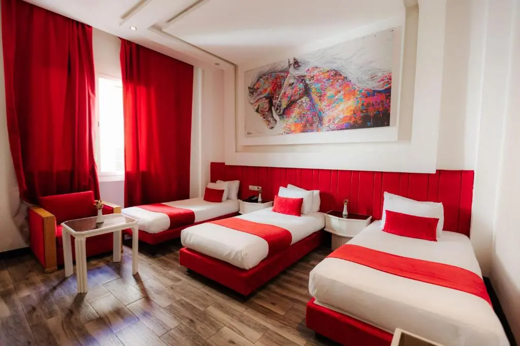 Red triple room with three single beds at Windsor Hotel City Center